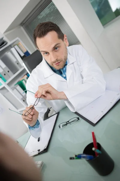 Trabalhador médico segurando galsses e falando com o paciente — Fotografia de Stock