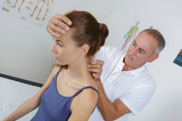 Mujer teniendo su cuello masajeado por un fisioterapeuta — Foto de Stock