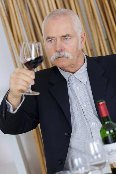 Senior uomo degustazione bere vino rosso — Foto Stock