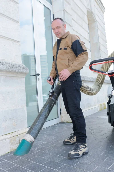 Limpiador de calles funciona con una aspiradora en la calle —  Fotos de Stock