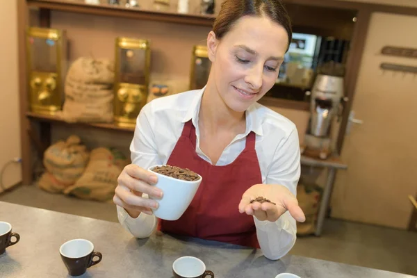 Operaia che tiene i chicchi di caffè in una caffetteria — Foto Stock