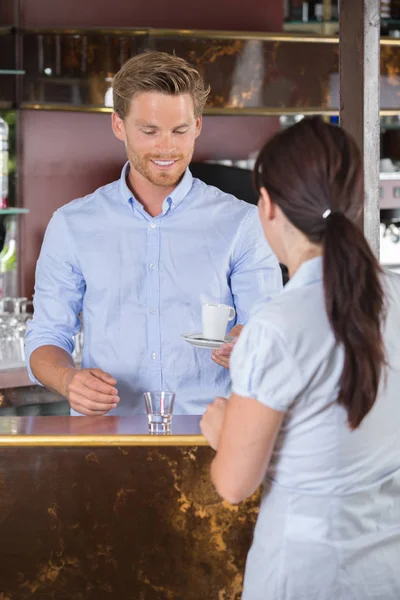 Müşteri bir barda kahve veren barmen — Stok fotoğraf