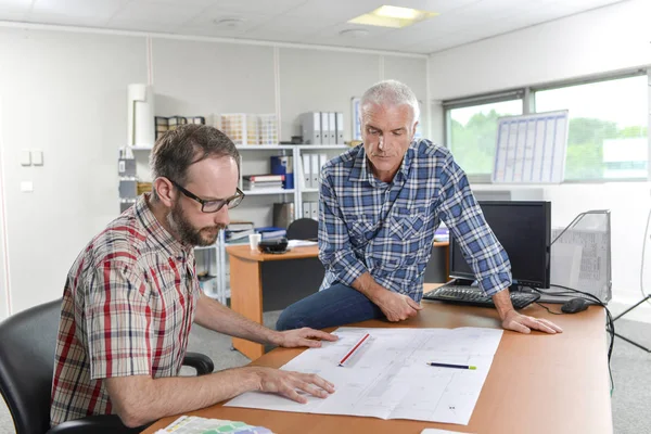 Två arkitekter samlades runt planer — Stockfoto