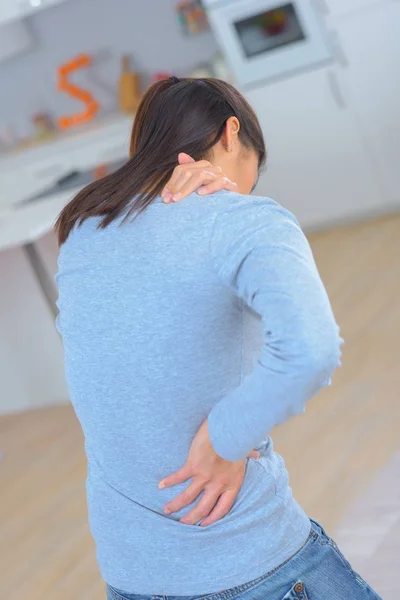 Aantrekkelijke vrouw met rugpijn thuis — Stockfoto