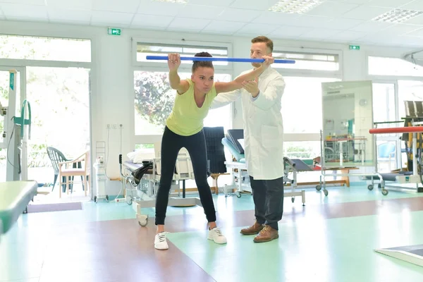 Junge Patientin macht körperliche Übungen in einer Rehabilitationsstudie — Stockfoto