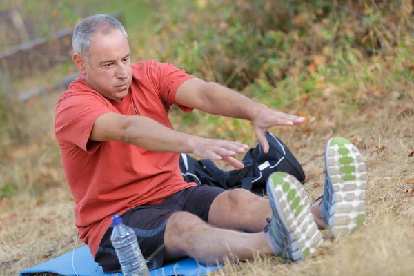 Uomo cercando di raggiungere i suoi piedi — Foto Stock