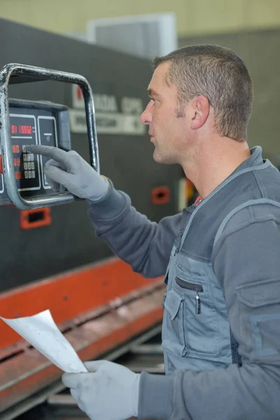 Operador masculino pressionando botões girando em uma máquina de precisão — Fotografia de Stock