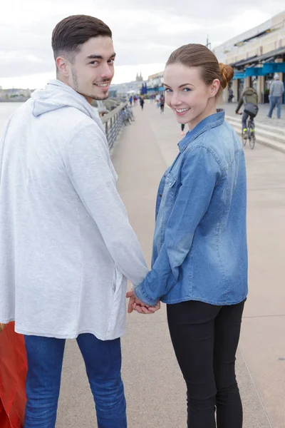 Молодая пара, держась за руки во время прогулки по городу — стоковое фото