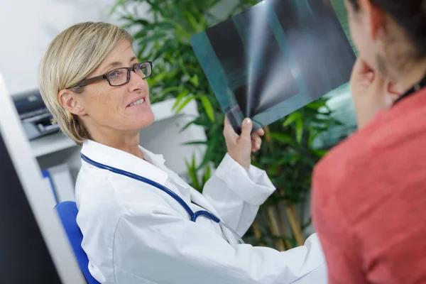 Medico con paziente che guarda i raggi X — Foto Stock