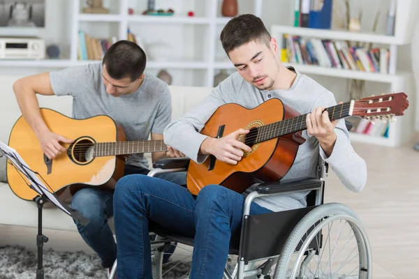 Gehandicapte gitarist en vriend — Stockfoto