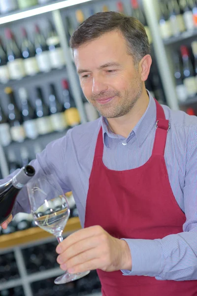 Wine merchant pouring glass of wine — Stock Photo, Image