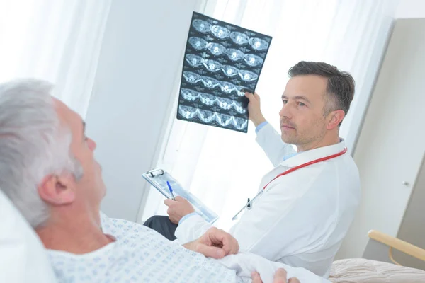 Médico mostrando xray para um paciente sênior no hospital — Fotografia de Stock