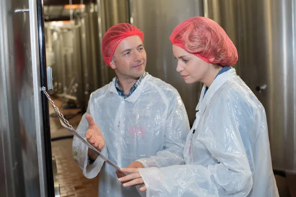 Consumo fabbrica lavoratori che indossano retina per capelli — Foto Stock