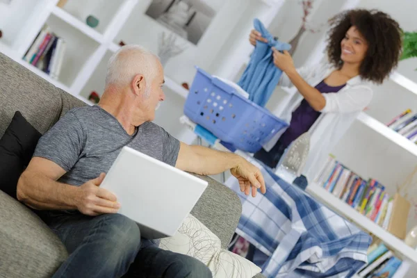 Oude man met behulp van de laptop terwijl het spreken aan zorg assistent — Stockfoto