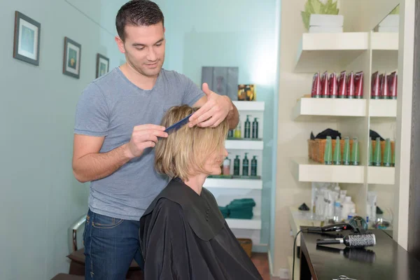 Pozitivní mladý muž stříhat vlasy dívka v kadeřnictví — Stock fotografie