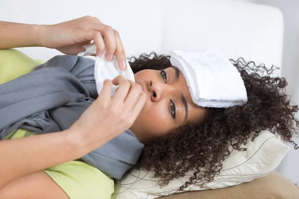 Sick female suffering from migraine with wet towel on head — Stock Photo, Image