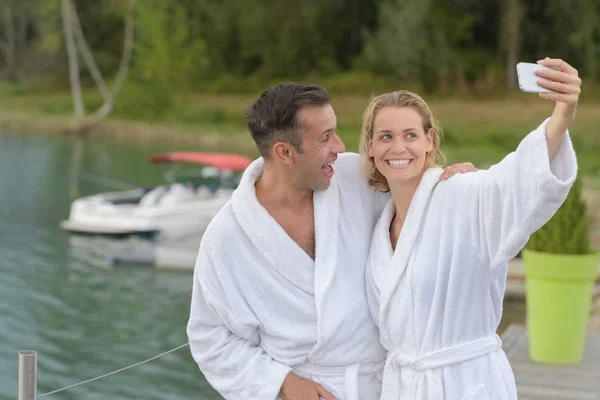 Couple on bathrobe taking selfie outside — Stock Photo, Image