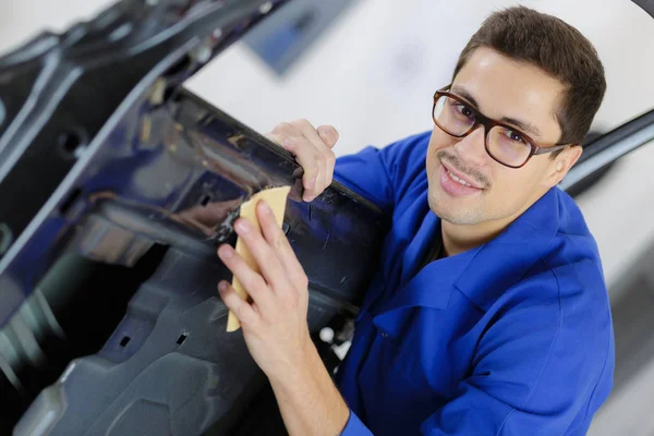 Concentrated handsome mechanic checking the door of the car — Stock Photo, Image