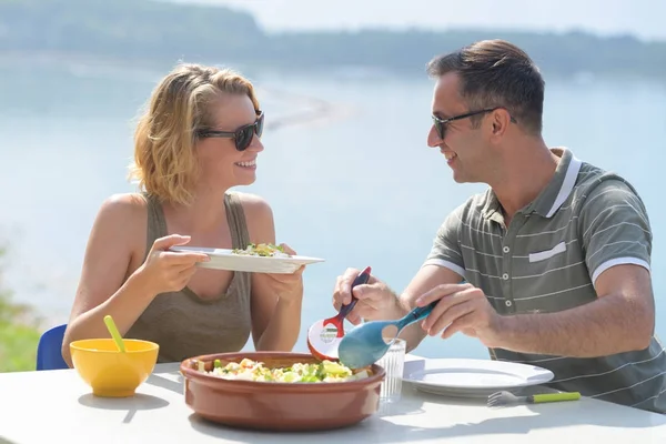 海の近くのテラスでサラダを食べるカップル — ストック写真