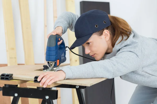 Legno da falegname femminile con un puzzle elettrico — Foto Stock