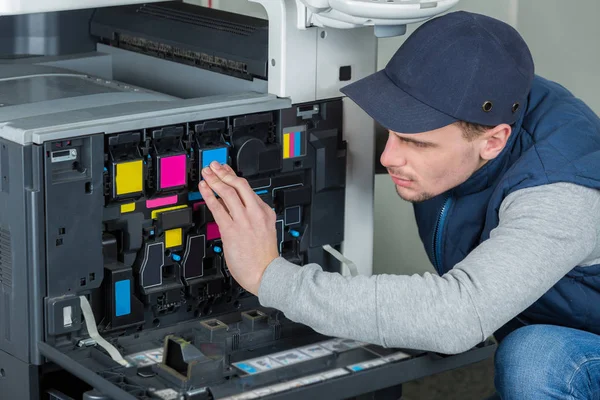 Homem verificando cartuchos de tinta na fotocopiadora — Fotografia de Stock