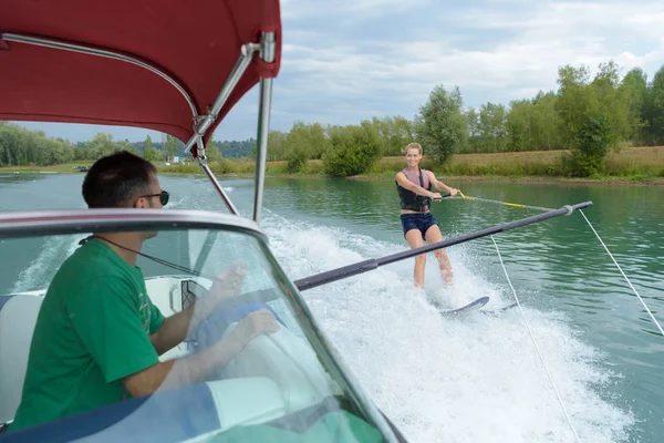 Jonge mooie vrouw rijden wakeboard op Golf van motorboot — Stockfoto