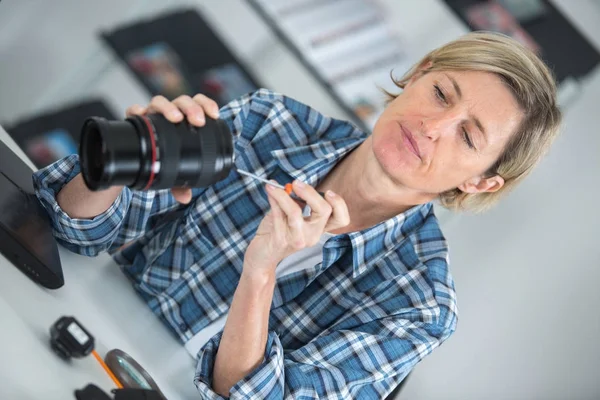 Mujer mirando lente fotográfica rota —  Fotos de Stock