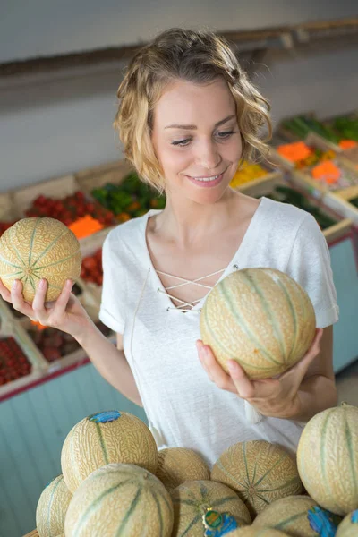 Mujer eligiendo melones en el supermercado — Foto de Stock