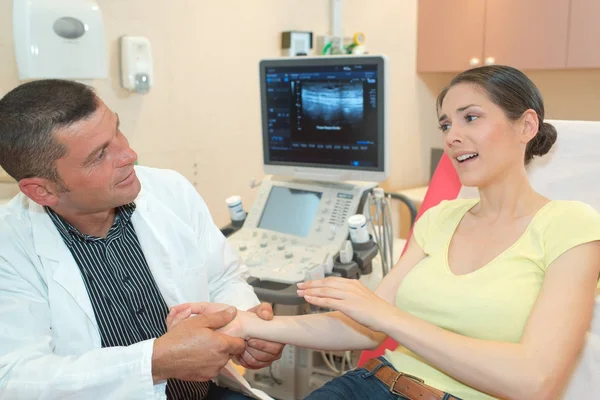 Male doctor performing ultrasound on woman in clinic — Stock Photo, Image