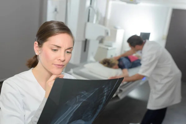 Jovem médica olhando para raio-x — Fotografia de Stock