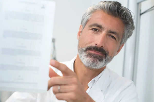 Handsome man showing you a sheet of paper — Stock Photo, Image