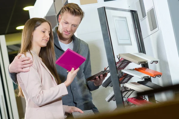 Joven pareja buscando azulejos baño en una tienda — Foto de Stock