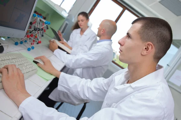 Jovens técnicos médicos que trabalham em laboratório — Fotografia de Stock