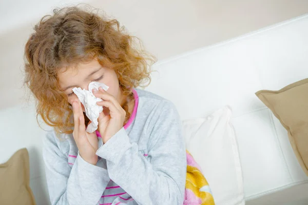 Young girl blowing her nose — Stok fotoğraf