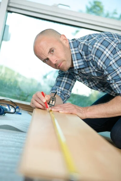 Porträtt av en snickare med hjälp av ett måttband — Stockfoto