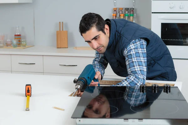 Ouvrier installant la table de cuisson dans la cuisine — Photo