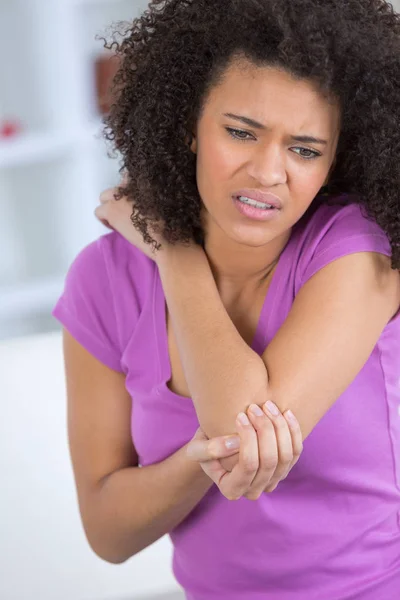 Een jonge vrouw aanraken haar pijnlijke elleboog — Stockfoto