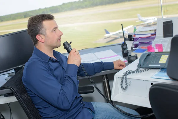 Mann kommuniziert vom Flughafen-Kontrollturm aus — Stockfoto