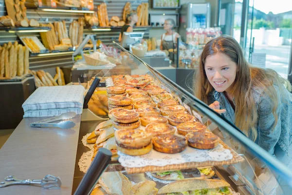 パン屋のカウンターでお探しの女性 — ストック写真