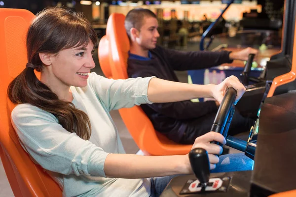 Young people at wheel of arcade games — Stock Photo, Image