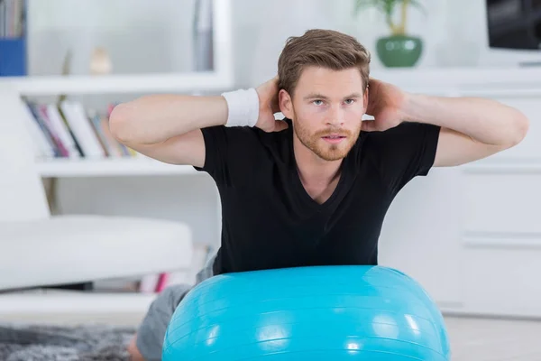 Joven con bola de yoga en el gimnasio — Foto de Stock