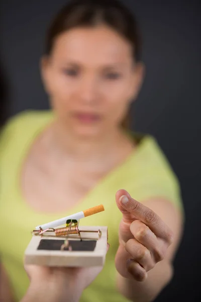 Woman trying to take a broken cigarettes from a trap — Stock Photo, Image