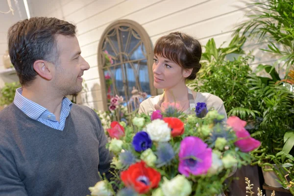 Kvinnliga florist och kund i blomsteraffär — Stockfoto