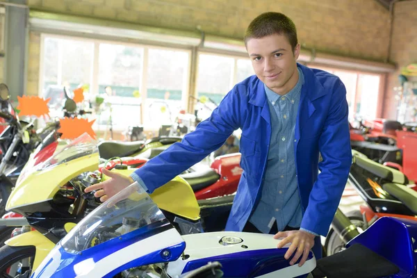 Young man buying motorbike in showroom — Stock Photo, Image
