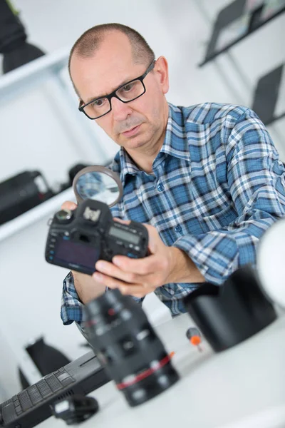 Male photographer checking dslr body at workplace — Stock Photo, Image