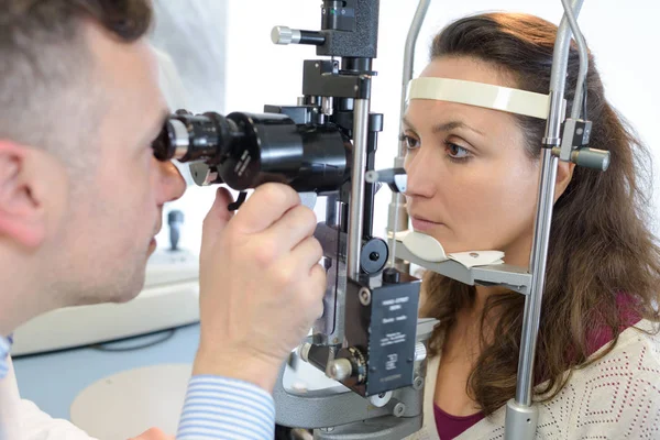 Optometrist examencommissie vrouwelijke patiënt in oogheelkunde kliniek — Stockfoto
