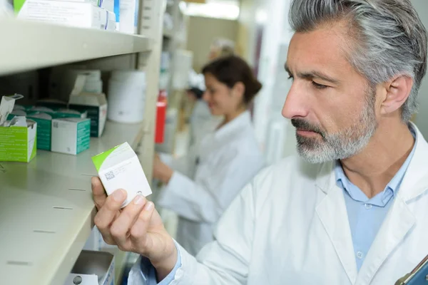 Farmacista che controlla i farmaci in farmacia — Foto Stock