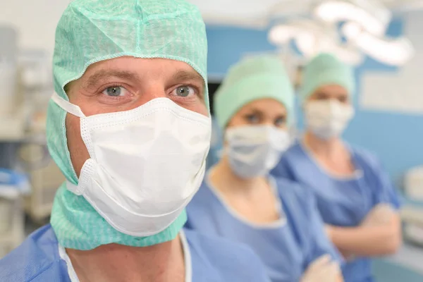 Sıradaki maskeleri giyen üç tıbbi işçi — Stok fotoğraf