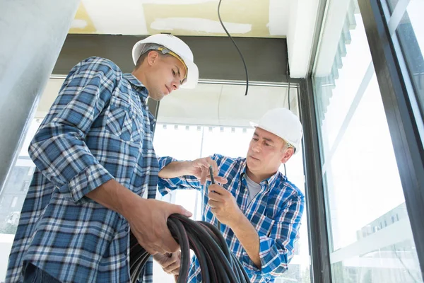 Leraar observeren van studenten die werken aan elektrische circuits — Stockfoto