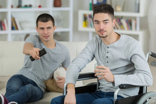 Joven discapacitado relajarse en casa con un amigo — Foto de Stock